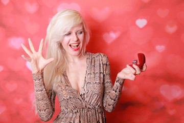 Female holding a box with a ring on red studio background