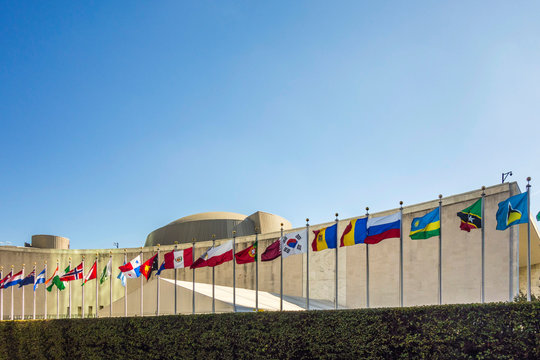 UN Nations building with flags of participating countries in afternoon sun