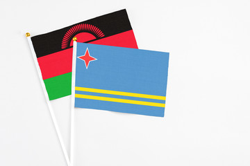 Aruba and Malawi stick flags on white background. High quality fabric, miniature national flag. Peaceful global concept.White floor for copy space.
