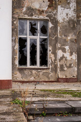 A window in an old house. Broken glass. Sharp pieces. Dirty concrete walls.