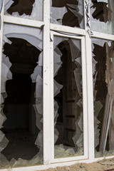 A window in an old house. Broken glass. Sharp pieces. Dirty concrete walls.