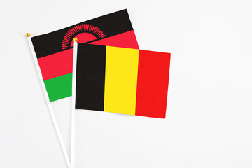 Belgium and Malawi stick flags on white background. High quality fabric, miniature national flag. Peaceful global concept.White floor for copy space.
