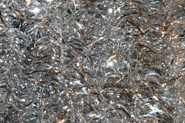 Shiny glitter background with silver tinsel macro texture. 