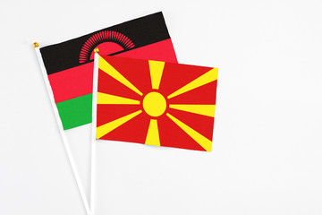 Macedonia and Malawi stick flags on white background. High quality fabric, miniature national flag. Peaceful global concept.White floor for copy space.