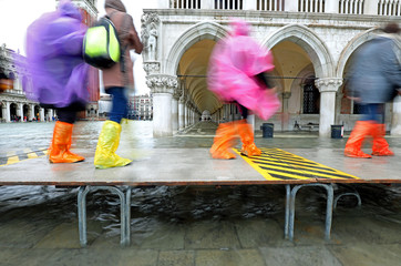 moving people with plastic leggings on the footbridge in Venice