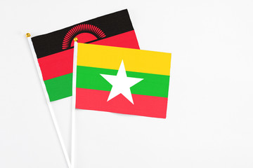 Myanmar and Malawi stick flags on white background. High quality fabric, miniature national flag. Peaceful global concept.White floor for copy space.