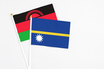 Nauru and Malawi stick flags on white background. High quality fabric, miniature national flag. Peaceful global concept.White floor for copy space.