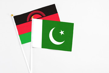 Pakistan and Malawi stick flags on white background. High quality fabric, miniature national flag. Peaceful global concept.White floor for copy space.