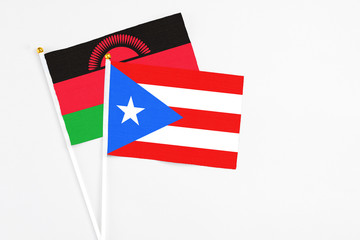 Puerto Rico and Malawi stick flags on white background. High quality fabric, miniature national flag. Peaceful global concept.White floor for copy space.