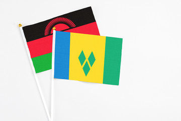 Saint Vincent And The Grenadines and Malawi stick flags on white background. High quality fabric,...