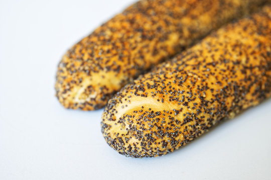 Hot Dog Buns With Poppy Seeds Are On A White Surface. Close-up. Macro. Shallow Depth Of Field