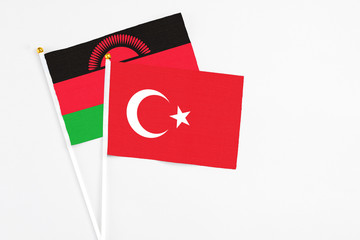 Turkey and Malawi stick flags on white background. High quality fabric, miniature national flag. Peaceful global concept.White floor for copy space.