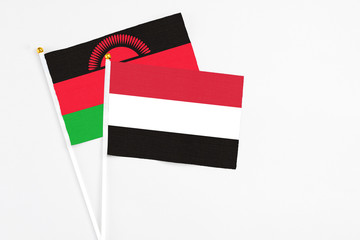 Yemen and Malawi stick flags on white background. High quality fabric, miniature national flag. Peaceful global concept.White floor for copy space.