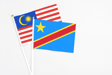 Congo and Malaysia stick flags on white background. High quality fabric, miniature national flag. Peaceful global concept.White floor for copy space.