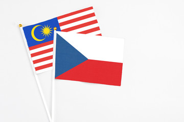 Obraz premium Czech Republic and Malaysia stick flags on white background. High quality fabric, miniature national flag. Peaceful global concept.White floor for copy space.
