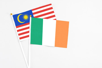 Ireland and Malaysia stick flags on white background. High quality fabric, miniature national flag. Peaceful global concept.White floor for copy space.