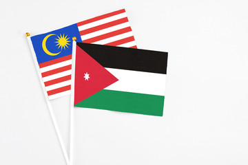 Jordan and Malaysia stick flags on white background. High quality fabric, miniature national flag. Peaceful global concept.White floor for copy space.