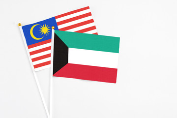 Kuwait and Malaysia stick flags on white background. High quality fabric, miniature national flag. Peaceful global concept.White floor for copy space.