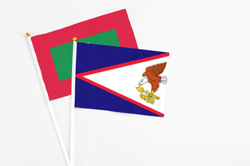 American Samoa and Maldives stick flags on white background. High quality fabric, miniature national flag. Peaceful global concept.White floor for copy space.