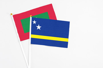 Curacao and Maldives stick flags on white background. High quality fabric, miniature national flag. Peaceful global concept.White floor for copy space.
