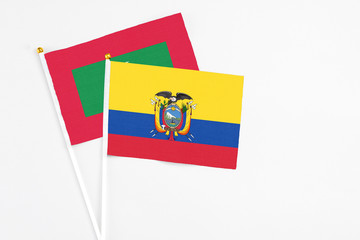 Ecuador and Maldives stick flags on white background. High quality fabric, miniature national flag. Peaceful global concept.White floor for copy space.