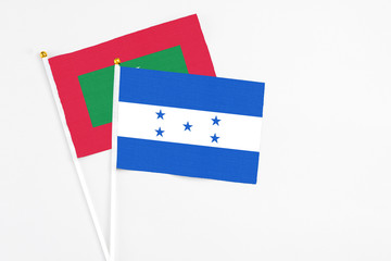 Honduras and Maldives stick flags on white background. High quality fabric, miniature national flag. Peaceful global concept.White floor for copy space.