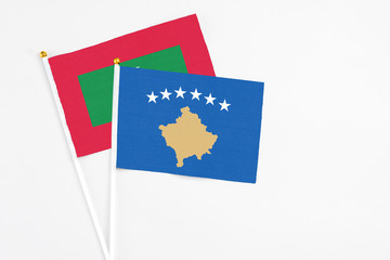Kosovo and Maldives stick flags on white background. High quality fabric, miniature national flag. Peaceful global concept.White floor for copy space.