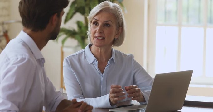 Older saleswoman bank manager explaining customer services benefits