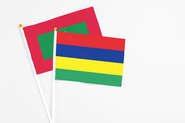 Mauritius and Maldives stick flags on white background. High quality fabric, miniature national flag. Peaceful global concept.White floor for copy space.