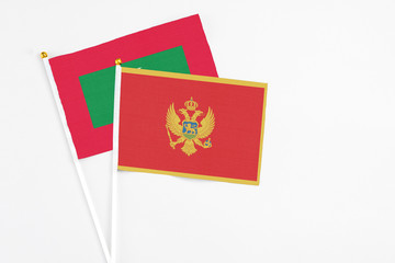 Montenegro and Maldives stick flags on white background. High quality fabric, miniature national flag. Peaceful global concept.White floor for copy space.