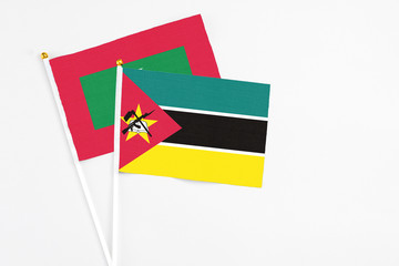 Mozambique and Maldives stick flags on white background. High quality fabric, miniature national flag. Peaceful global concept.White floor for copy space.
