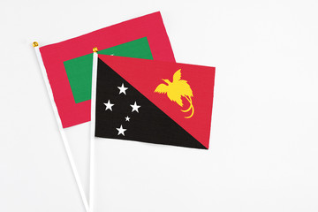 Papua New Guinea and Maldives stick flags on white background. High quality fabric, miniature national flag. Peaceful global concept.White floor for copy space.