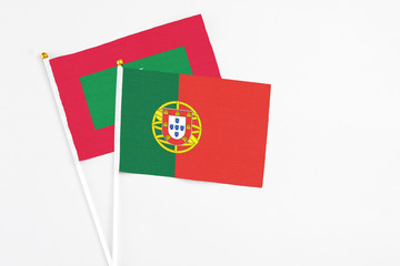 Portugal and Maldives stick flags on white background. High quality fabric, miniature national flag. Peaceful global concept.White floor for copy space.