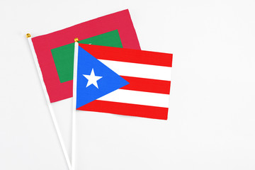 Puerto Rico and Maldives stick flags on white background. High quality fabric, miniature national flag. Peaceful global concept.White floor for copy space.