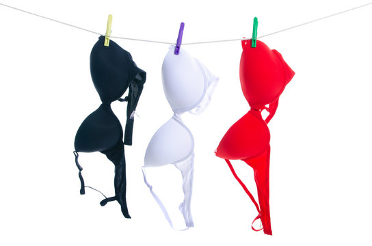 Female bras on clothespins rope on white background isolation