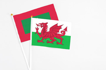 Wales and Maldives stick flags on white background. High quality fabric, miniature national flag. Peaceful global concept.White floor for copy space.