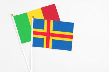 Aland Islands and Mali stick flags on white background. High quality fabric, miniature national flag. Peaceful global concept.White floor for copy space.