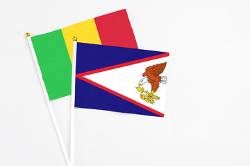 American Samoa and Mali stick flags on white background. High quality fabric, miniature national flag. Peaceful global concept.White floor for copy space.