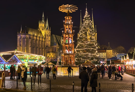 Erfurt, Germany. Christmas pyramid at Christmas market on Domplatz (Cathedral Square) in night. St Mary's Cathedral is visible in the background. Church of St Severus is hidden by the Christmas tree.