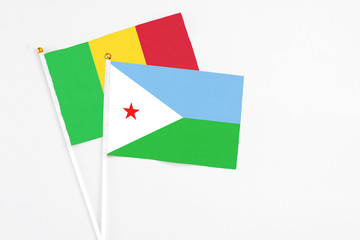 Djibouti and Mali stick flags on white background. High quality fabric, miniature national flag. Peaceful global concept.White floor for copy space.