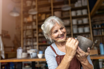 Senior woman pottery artist makes ceramics from clay