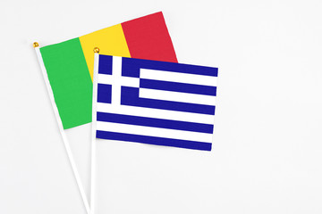 Greece and Mali stick flags on white background. High quality fabric, miniature national flag. Peaceful global concept.White floor for copy space.