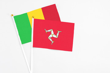 Isle Of Man and Mali stick flags on white background. High quality fabric, miniature national flag. Peaceful global concept.White floor for copy space.