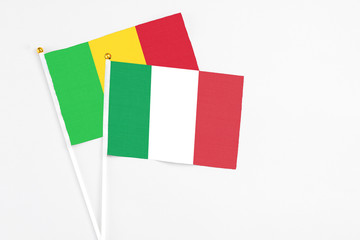 Italy and Mali stick flags on white background. High quality fabric, miniature national flag. Peaceful global concept.White floor for copy space.