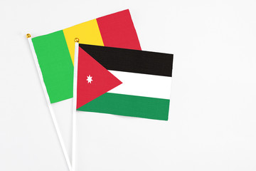 Jordan and Mali stick flags on white background. High quality fabric, miniature national flag. Peaceful global concept.White floor for copy space.