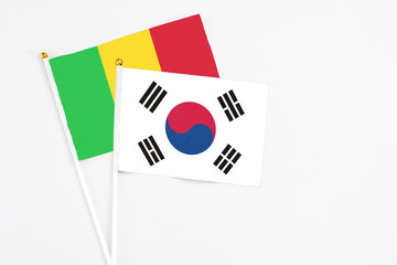 South Korea and Mali stick flags on white background. High quality fabric, miniature national flag. Peaceful global concept.White floor for copy space.