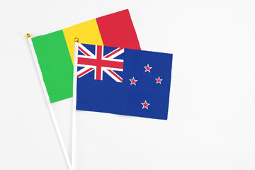 Fototapeta premium New Zealand and Mali stick flags on white background. High quality fabric, miniature national flag. Peaceful global concept.White floor for copy space.
