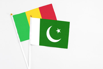Pakistan and Mali stick flags on white background. High quality fabric, miniature national flag. Peaceful global concept.White floor for copy space.