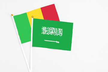 Saudi Arabia and Mali stick flags on white background. High quality fabric, miniature national flag. Peaceful global concept.White floor for copy space.