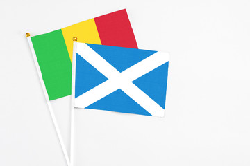 Scotland and Mali stick flags on white background. High quality fabric, miniature national flag. Peaceful global concept.White floor for copy space.